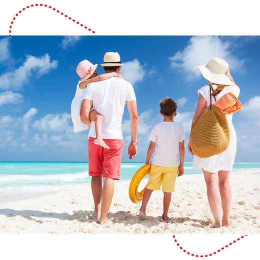 family walking on sandy tropical beach on a sunny day