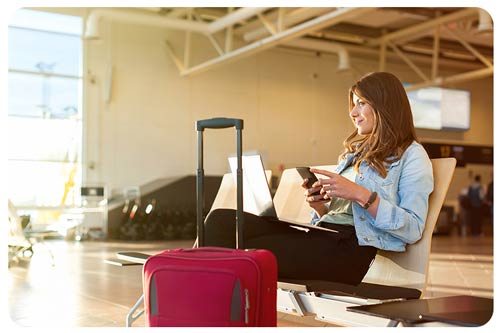 Woman at airport looking at a smartphone