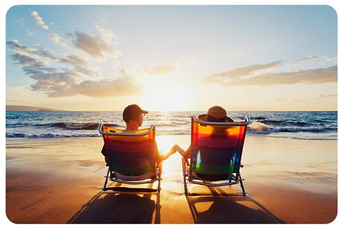 couple in beach chairs watching sunset at the beach