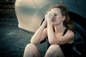 Person sitting beside car