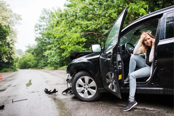 Black SUV damaged from an accident, driver calling to make insurance claim