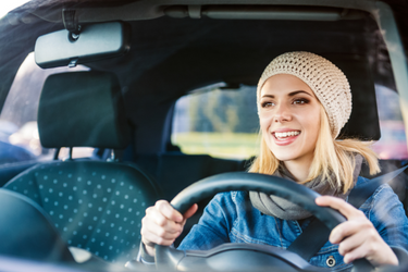 Blonde woman with hat driving