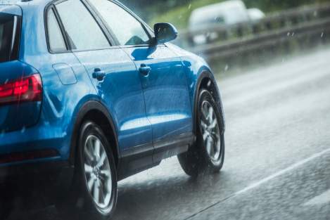 blue car driving in the rain