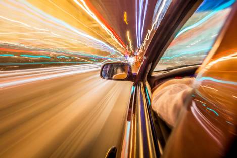 orange hued photo of a car driving fast