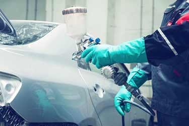 silver car being spray painted