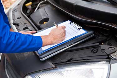 mechanic taking notes on car