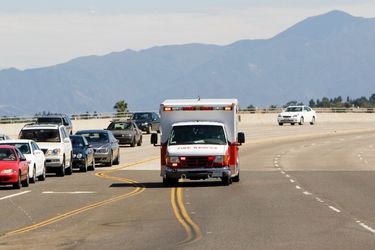 cars on the side of the road oncoming ambulance