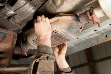 person holding catalytic converter