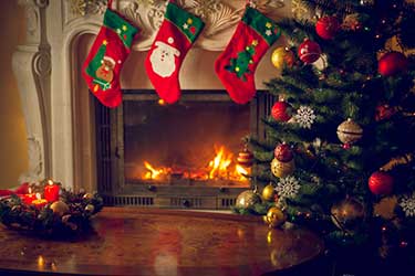 Christmas tree beside a fire with stockings hung