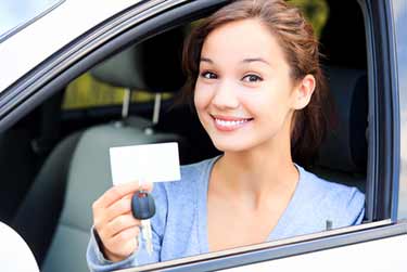young woman after passing driving test in a car