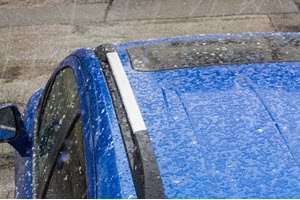 Hail falling on blue SUV