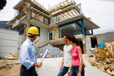 contractors talking to family outside a home being built