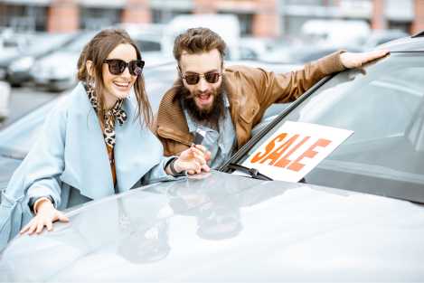 couple at used car dealership looking at a car