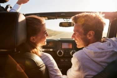 couple planning trip with map while driving