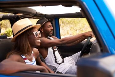 black couple driving jeep