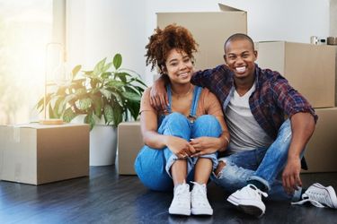 Couple sitting amongst moving boxes