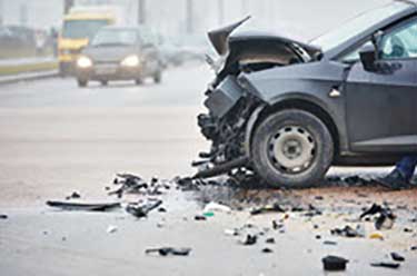 Gray car with front end damaged after a collision