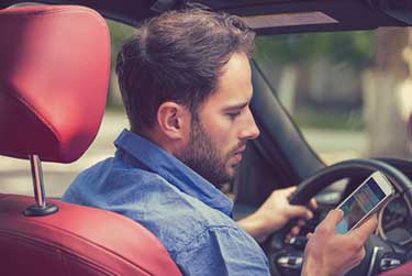 Man looking at his phone while driving