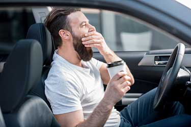 Man Driving When Tired And Drinking Coffee