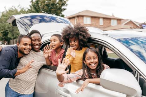 family standing around a car