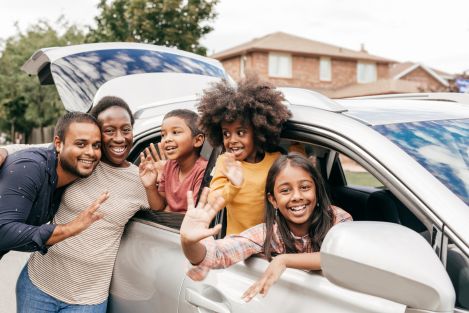 family standing around car