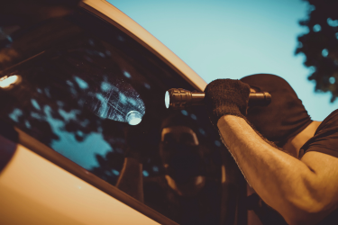 thief flashing a light on a car window