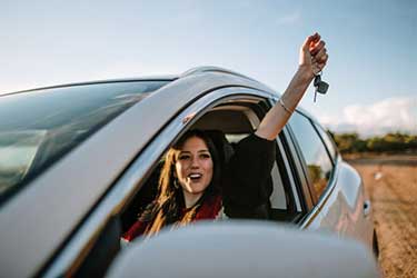 Young excited woman in a car