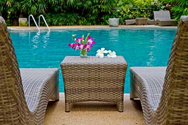 Two chairs and table by a swimming pool