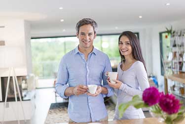 couple in kitchen holding mugs 