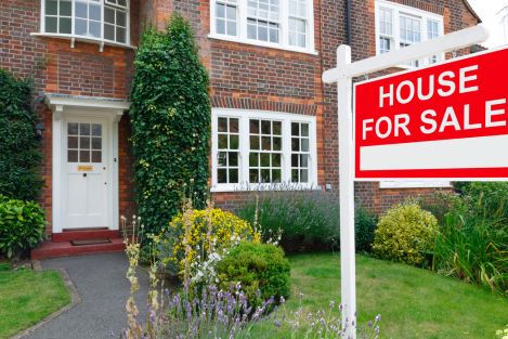 house with for sale sign on lawn