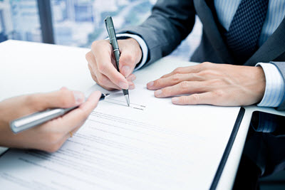 Person signing agreement with pen