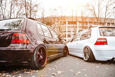 two modified cars parked beside each other