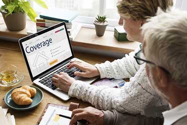 older couple looking at insurance coverage on a laptop