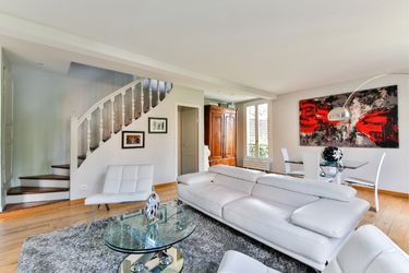 Living room with white couch and walls with abstract red art