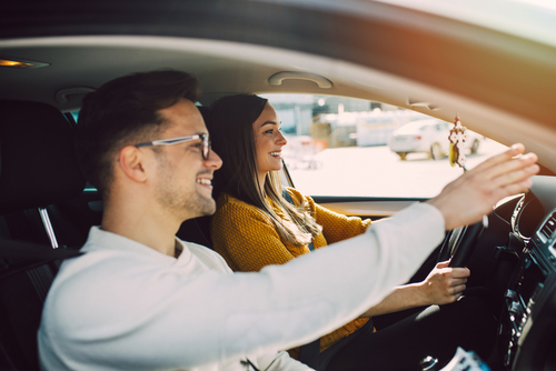 Male driving teacher in car with student