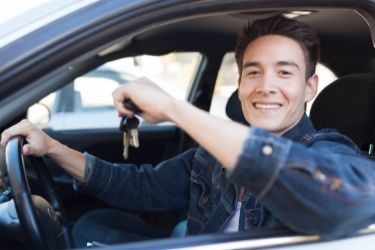 young man getting in car with keys