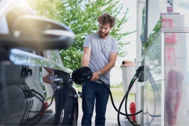 man filling up car with gas
