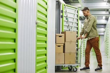 Man moving boxes at storage facility 