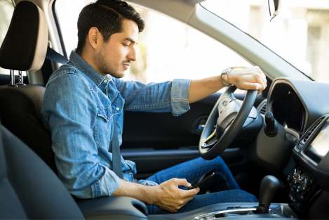 man texting and driving in his car