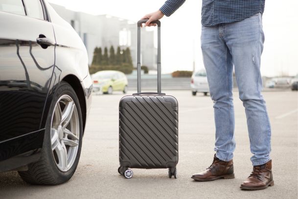 man with suitcase leaving with rental car covered with opcf 27