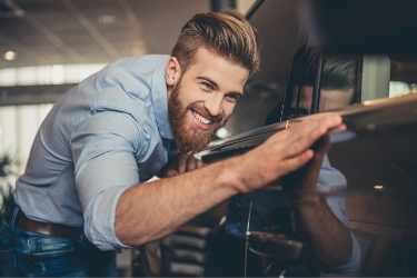 man with beard looking at car