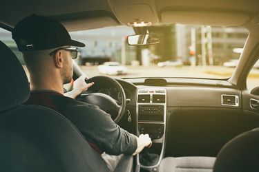 Ontario Demerit Points System 2 man driving with hat during golden hour