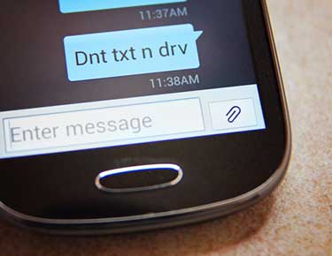 Smart phone text saying dnt txt n drv