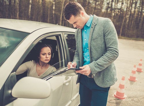 driving instructor showing a female student in a car test results