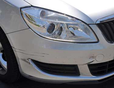 silver car with damaged front fender and bumper