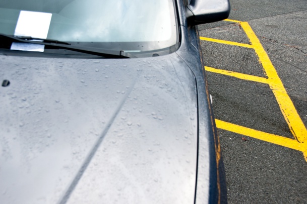 parking ticket on window of a car on a rainy day