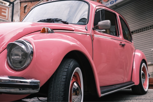 pink vintage car parked on road