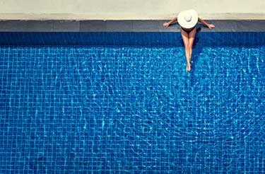 woman sitting by a swimming pool