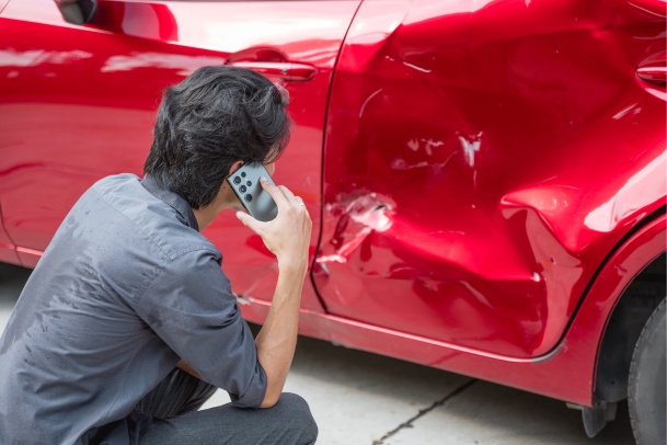 man calling insurance company after a fault car accident