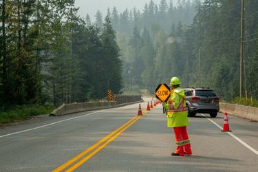 Construction worker holding sign to slow down